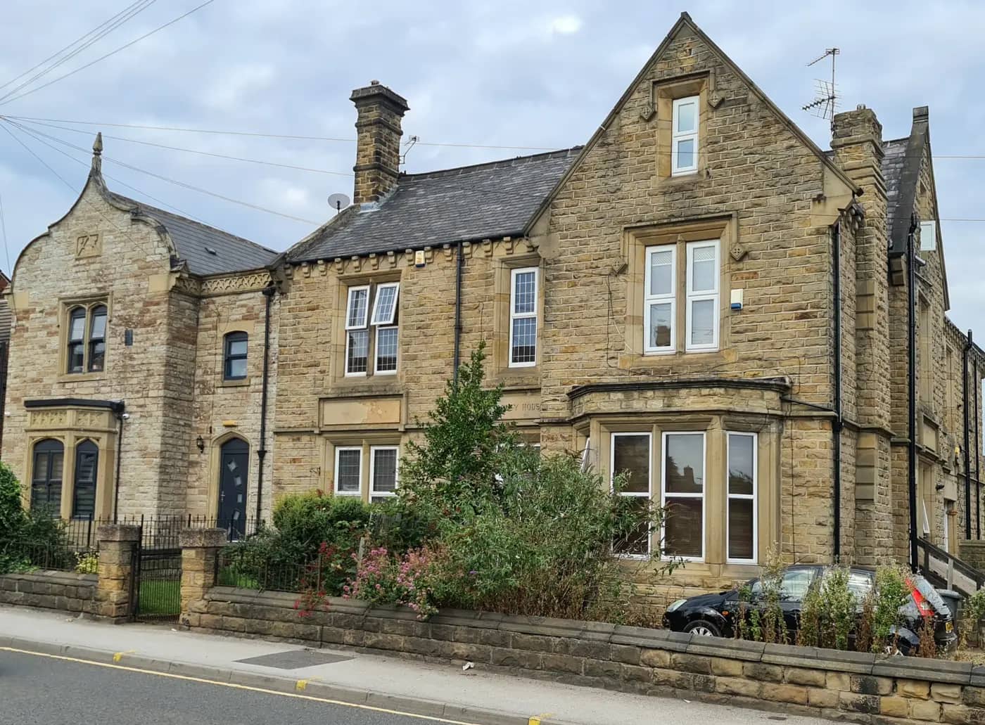 Victorian stone villas with gabled roofs behind a low wall on Dodworth Road, Barnsley
