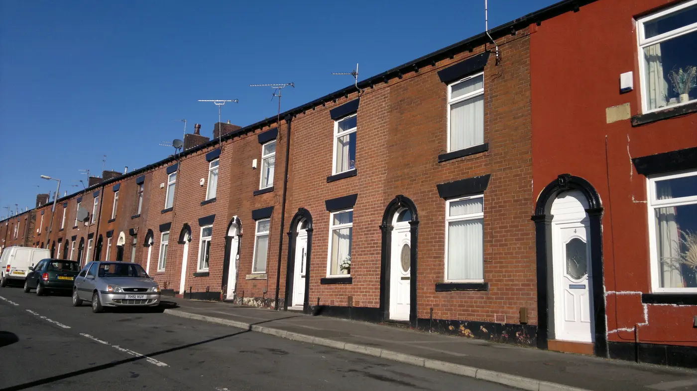 Red-brick terraced houses with arched doorways on Afghan Street, Oldham
