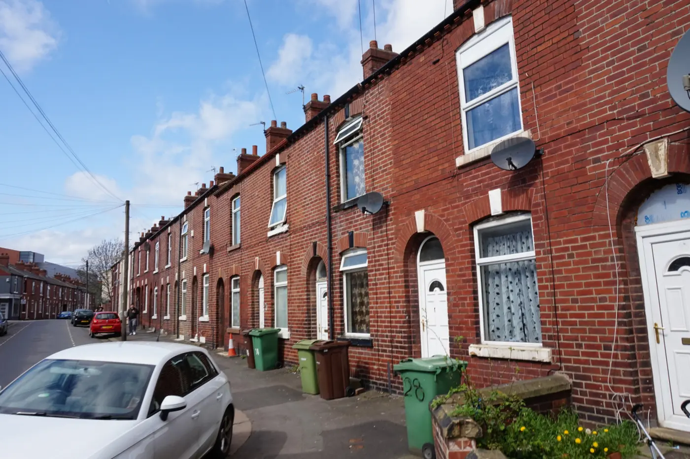 A long row of red-brick terraced houses with arched doorways on Earl Street, Wakefield