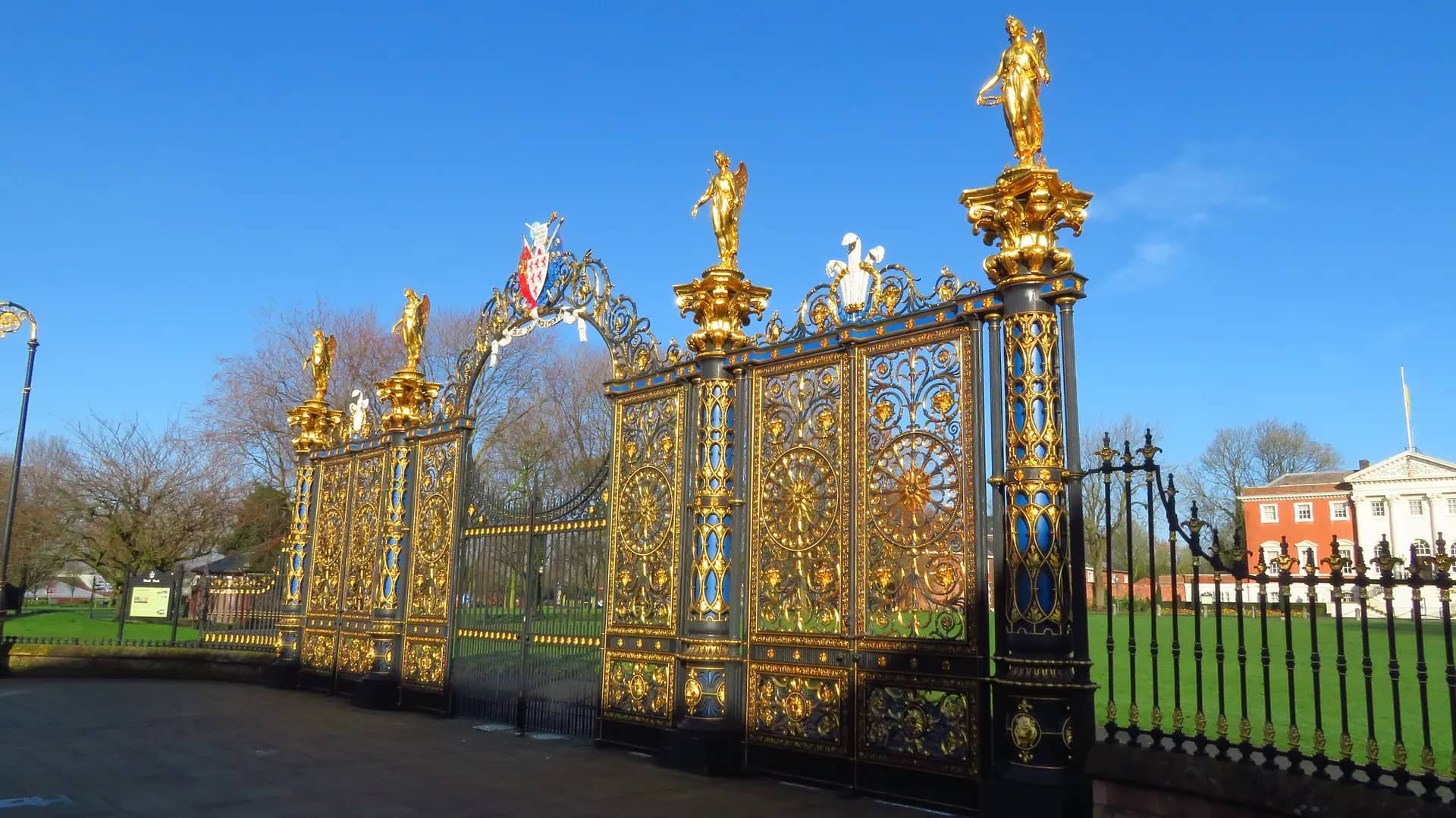 The ornate Golden Gates of Warrington Town Hall in sunshine, with the town hall behind