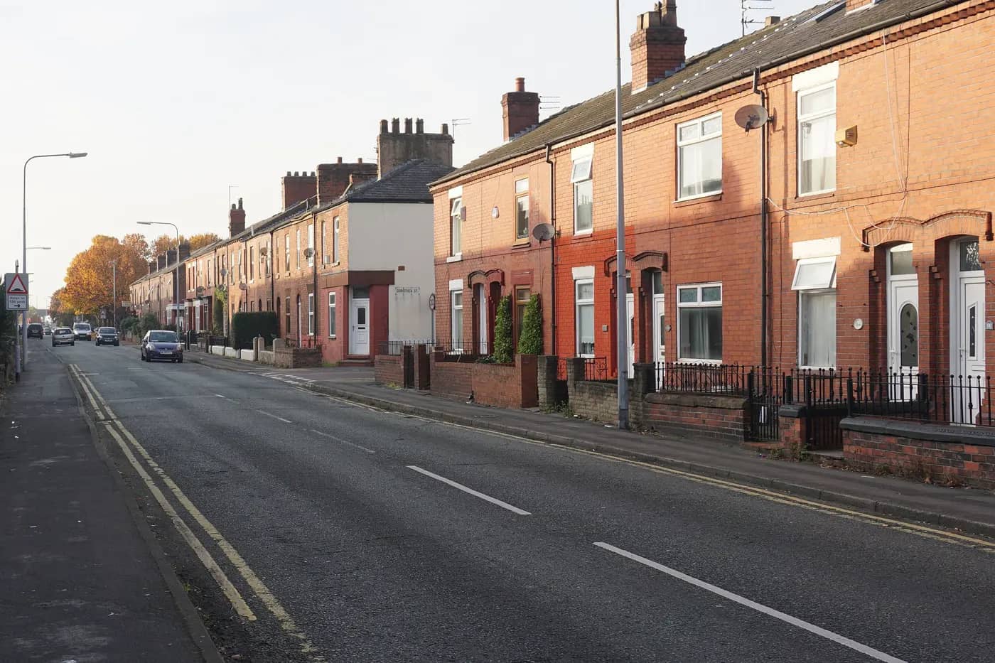 Red-brick terraced houses on Longford Street, Warrington, in low autumn sun