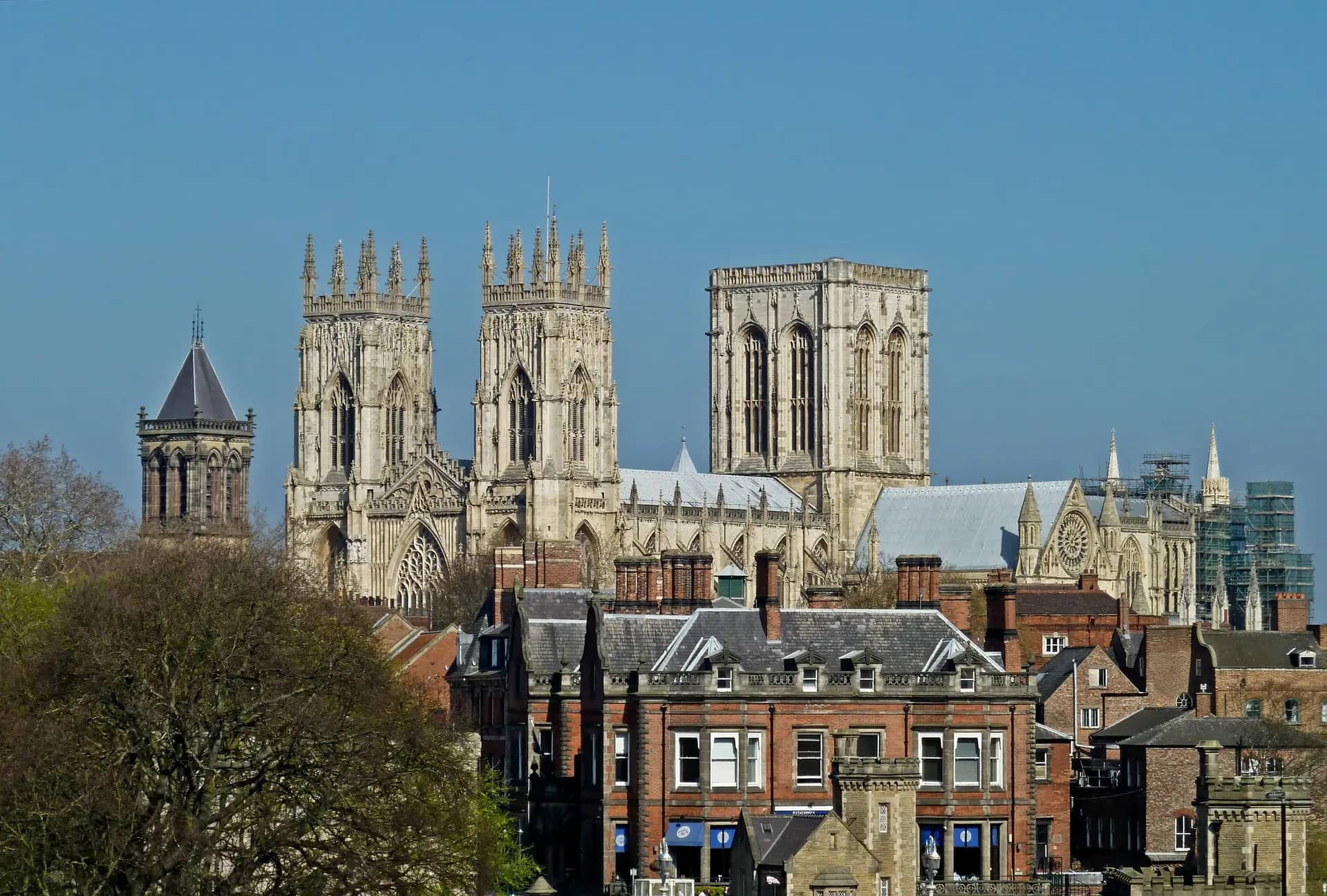 The towers of York Minster rising above red-brick and slate rooftops, seen from the city walls