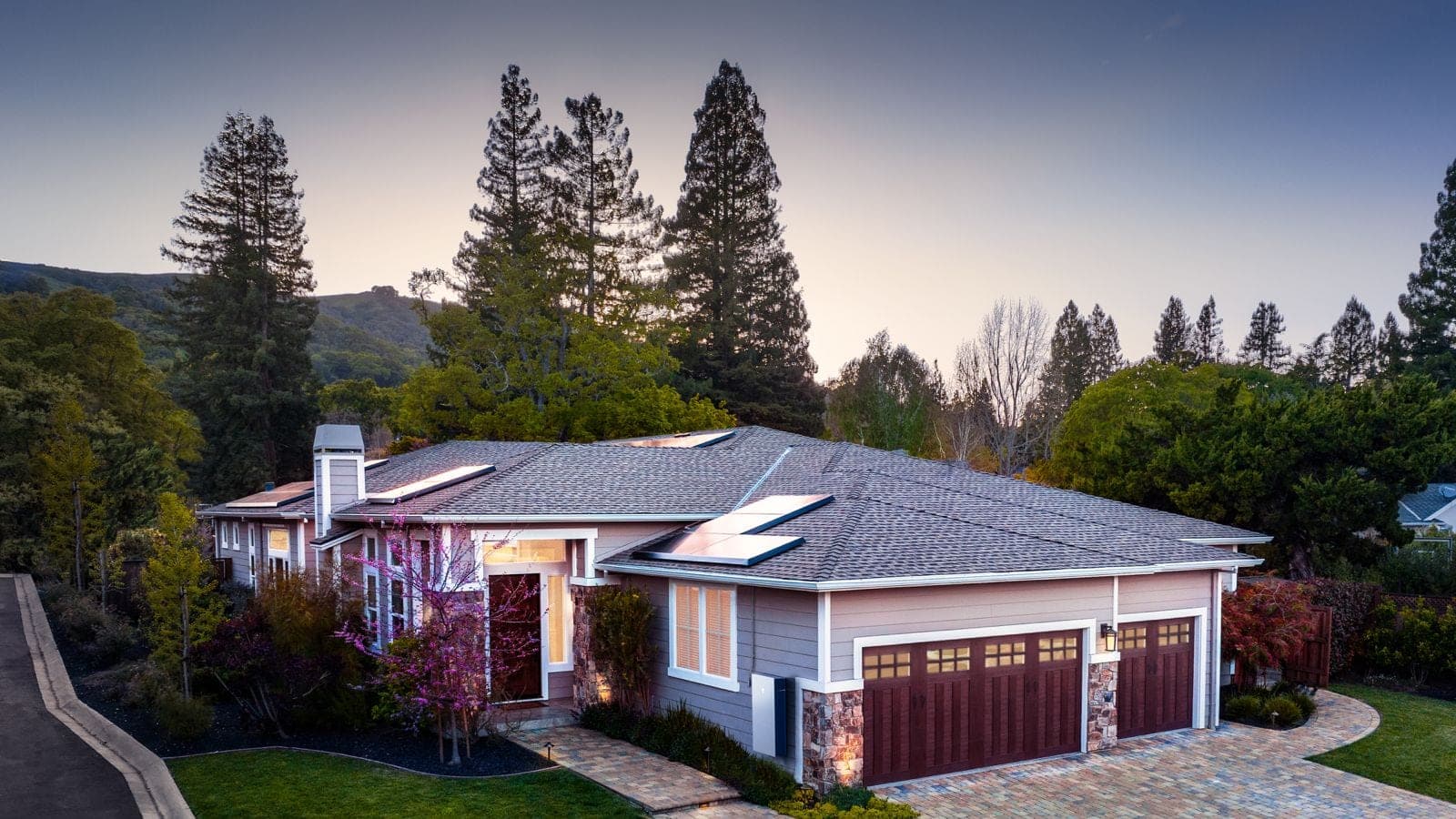 A detached house at dusk with a solar array across the main roof