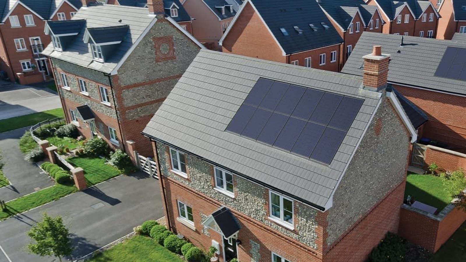 New-build brick and flint houses with all-black solar panels on their roofs