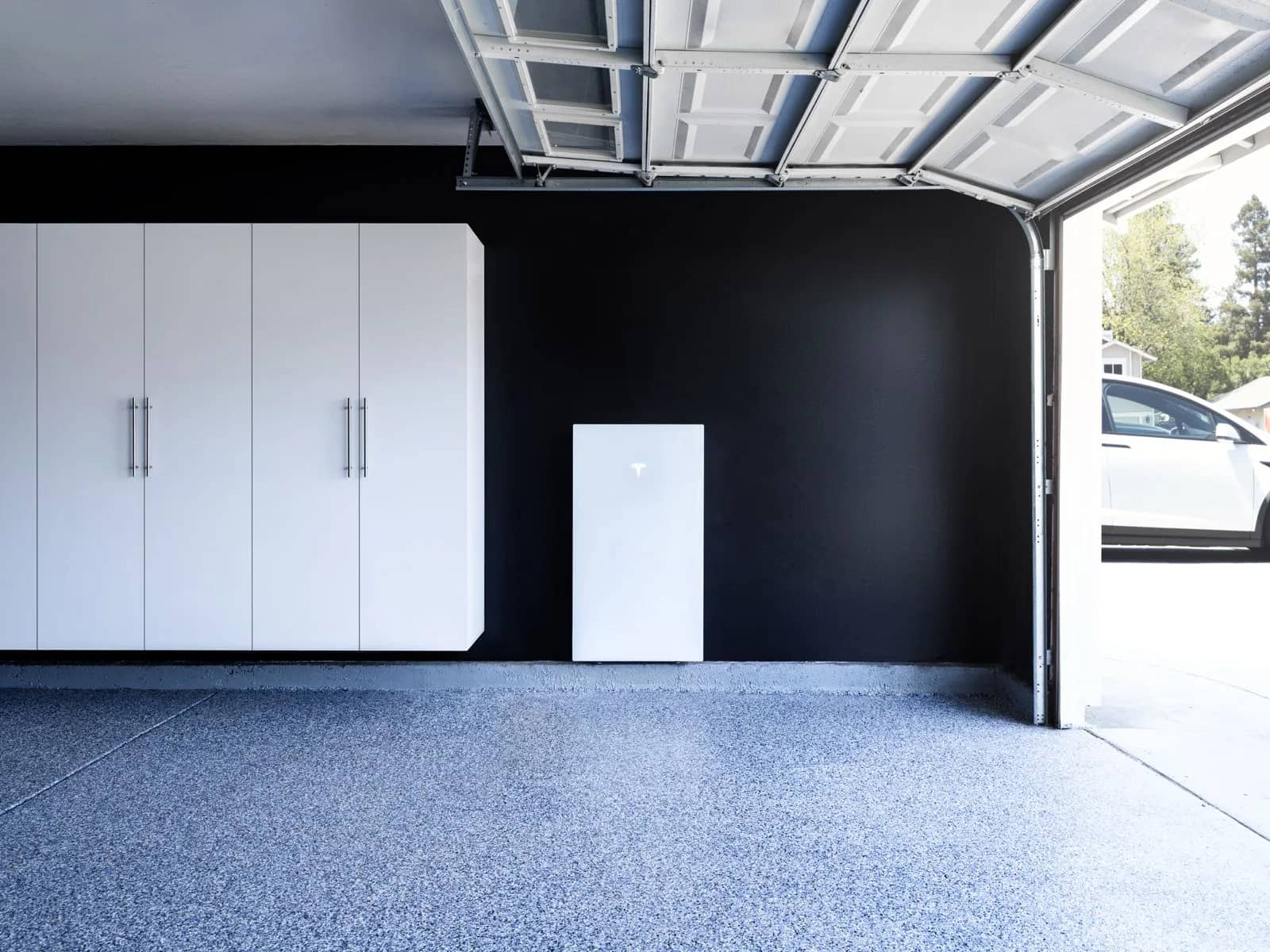 A battery and inverter mounted on a garage wall beside the door