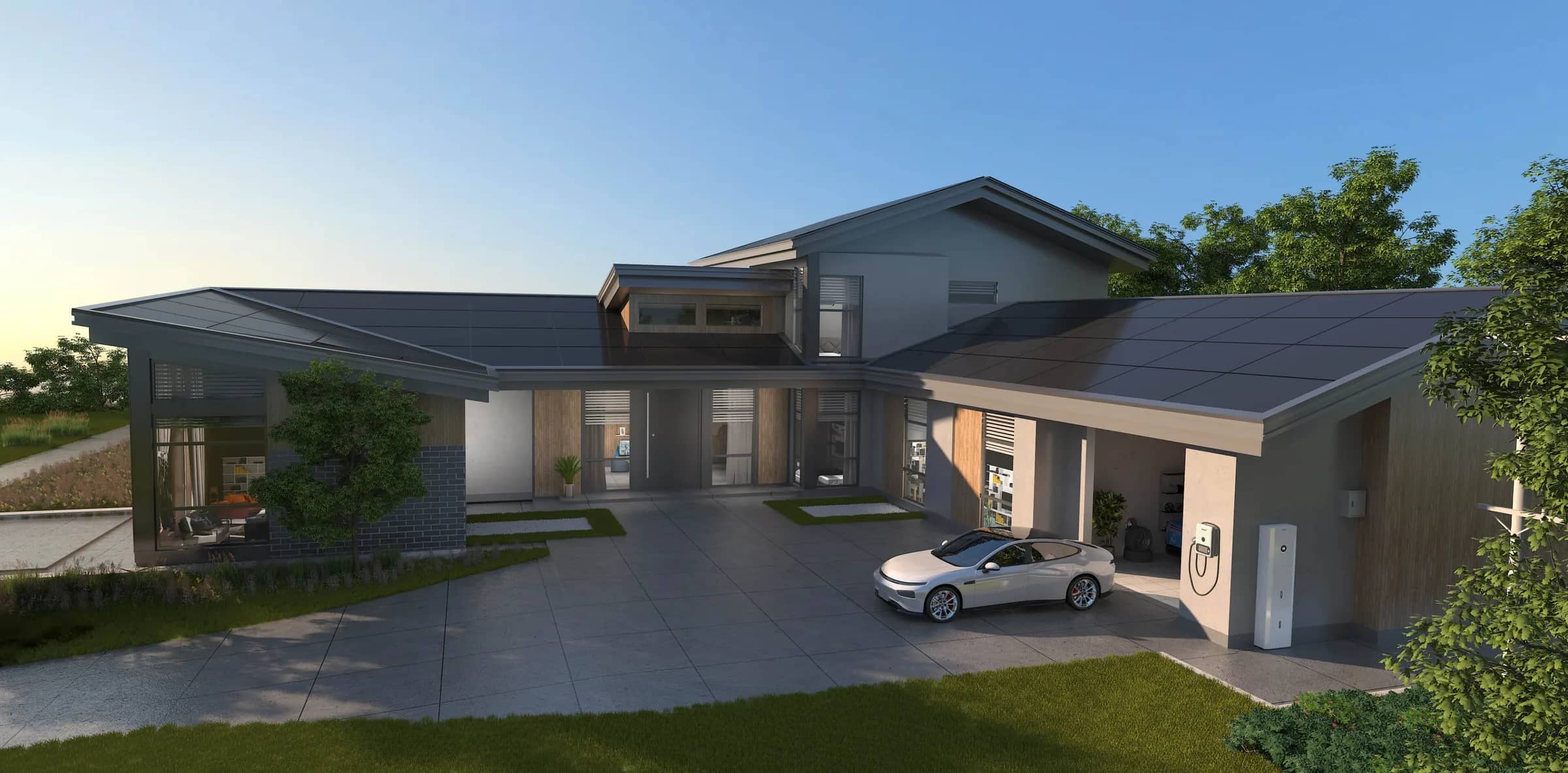 A modern house on a clear day with an all-black solar array across the roof and a car on the drive