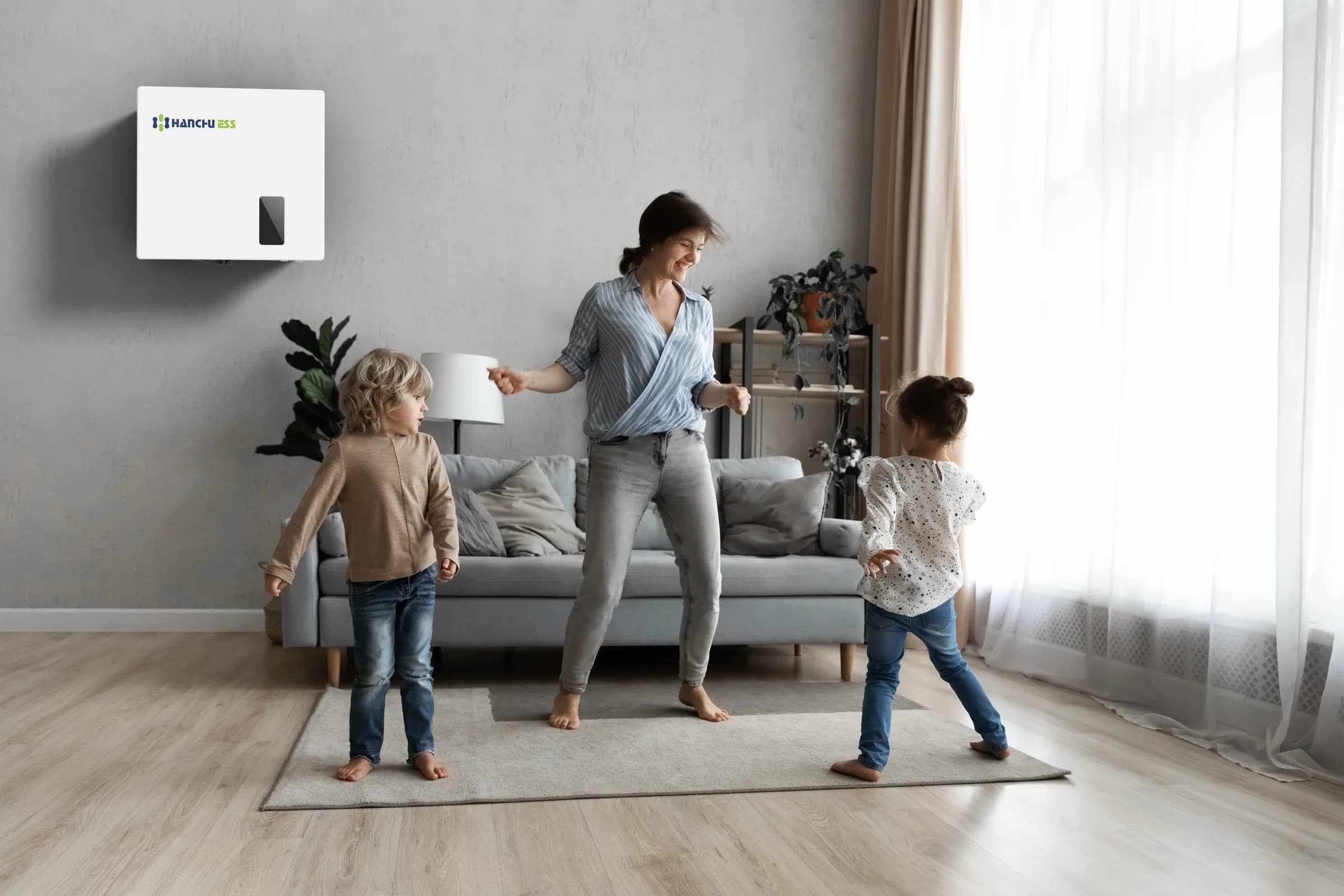 A family in a bright living room with a hybrid inverter fitted on the wall
