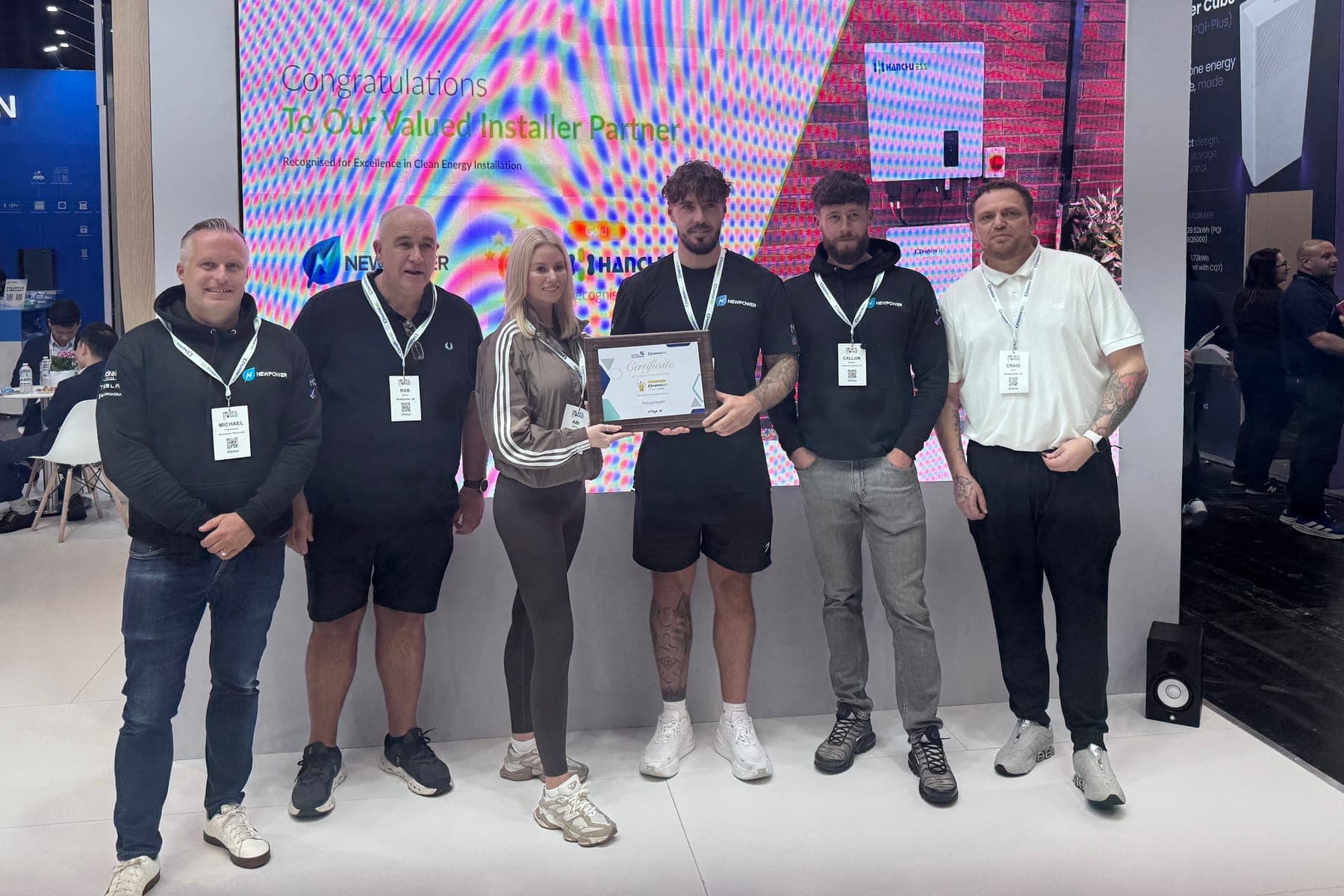 Six of the Newpower team on the Hanchu ESS stand, holding the installer partner certificate